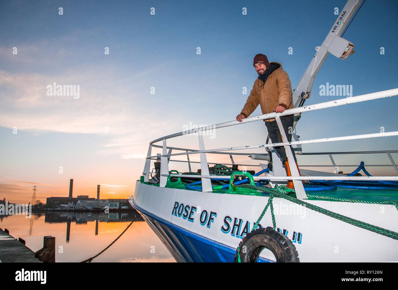 Cork City, Cork, Ireland. 11th March, 2019. Macdara Breathnach from Connemara and Skipper of the trawler Rose of Sharon, stands on the deck watching the unloading of Prawns that are bound for export at Horgan's Quay, Cork City, Ireland. Credit: David Creedon/Alamy Live News Stock Photo