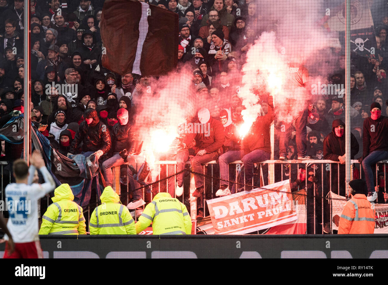 Hamburg, Deutschland. 10th Mar, 2019. St.Pauli Ultras provoke with HSV  Hamburg Hamburg Hamburg fan articles and ending fireworks, pyrotechnics,  pyro, bengalos, bengali lights, smoke, smoke bomb, fan, fans, spectators,  supporters, supporters, ultra,