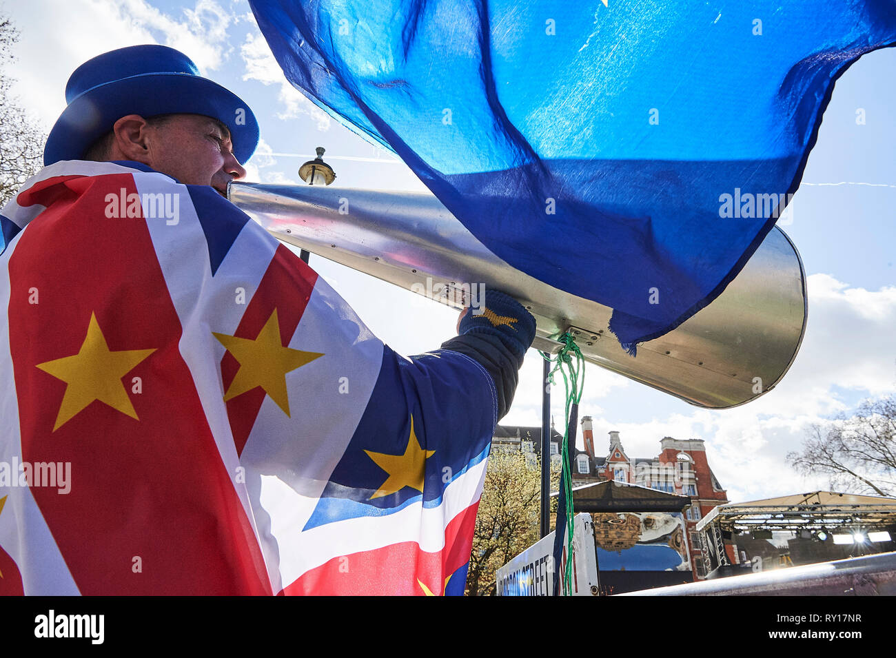 London, UK. 11th March 2019. Streven Bray, Pro remain campaigner, enjoy the sun outside Parliament. Credit: Thomas Bowles/Alamy Live News Stock Photo