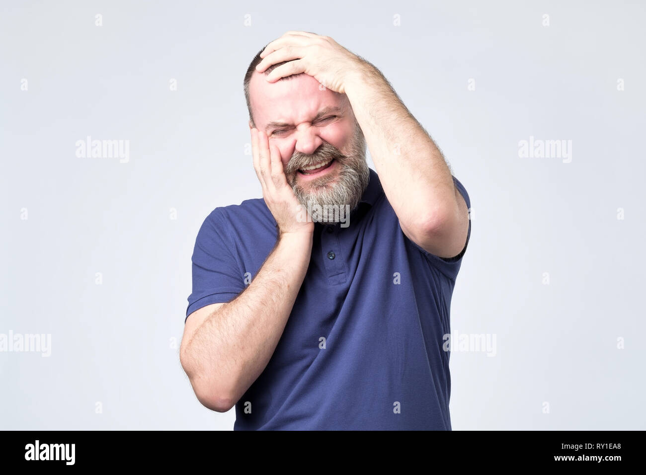 Mature european man with beard is crying in panic. Stock Photo