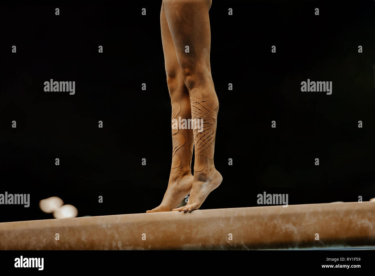 legs women gymnasts in kinesio tape on balance beam Stock Photo