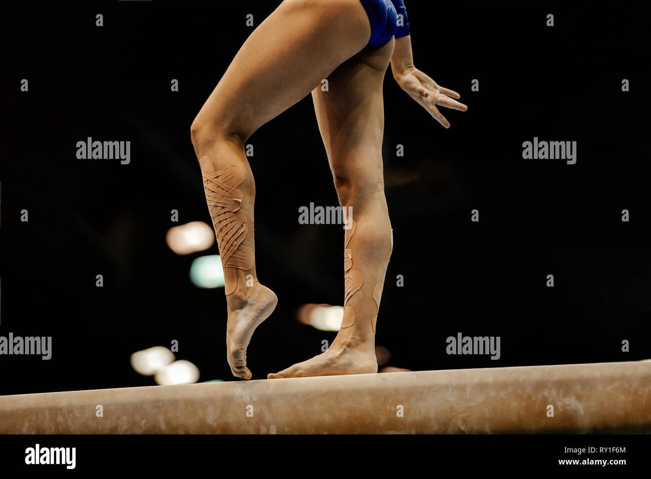 legs women gymnasts on balance beam on black background Stock Photo