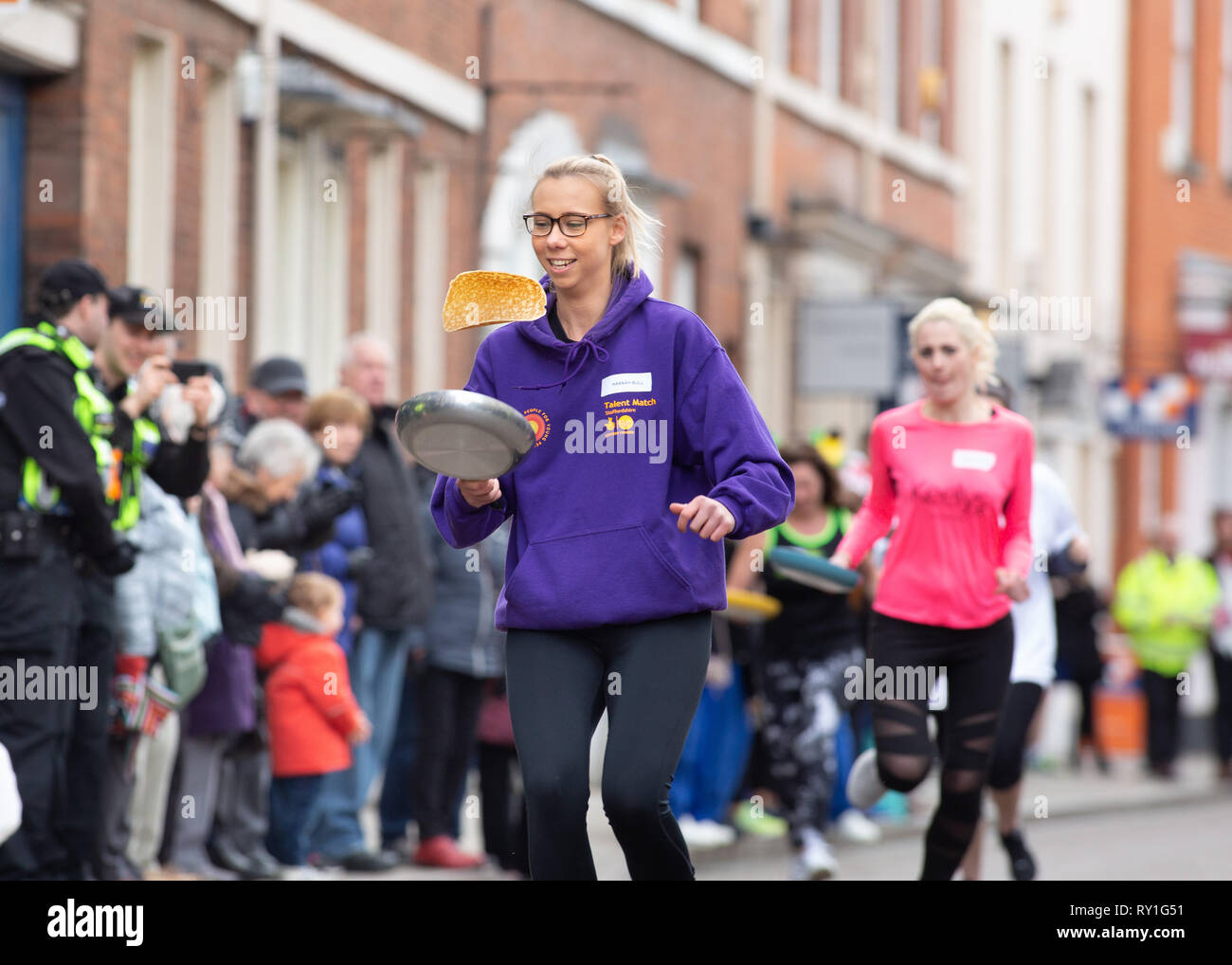 The annual Shrove Tuesday pancake race taking place in Bore Street, Lichfield, England, UK Stock Photo