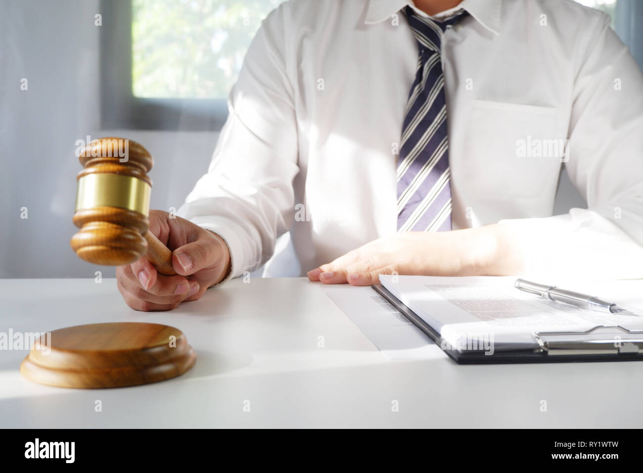 Judge hitting gavel and the report of the case with note paper on table, Law and justice concept. Stock Photo