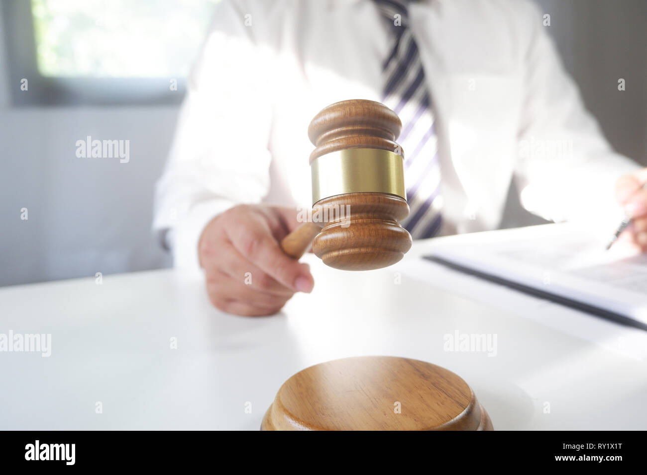 Judge hitting gavel and the report of the case with note paper on table, Law and justice concept. Stock Photo