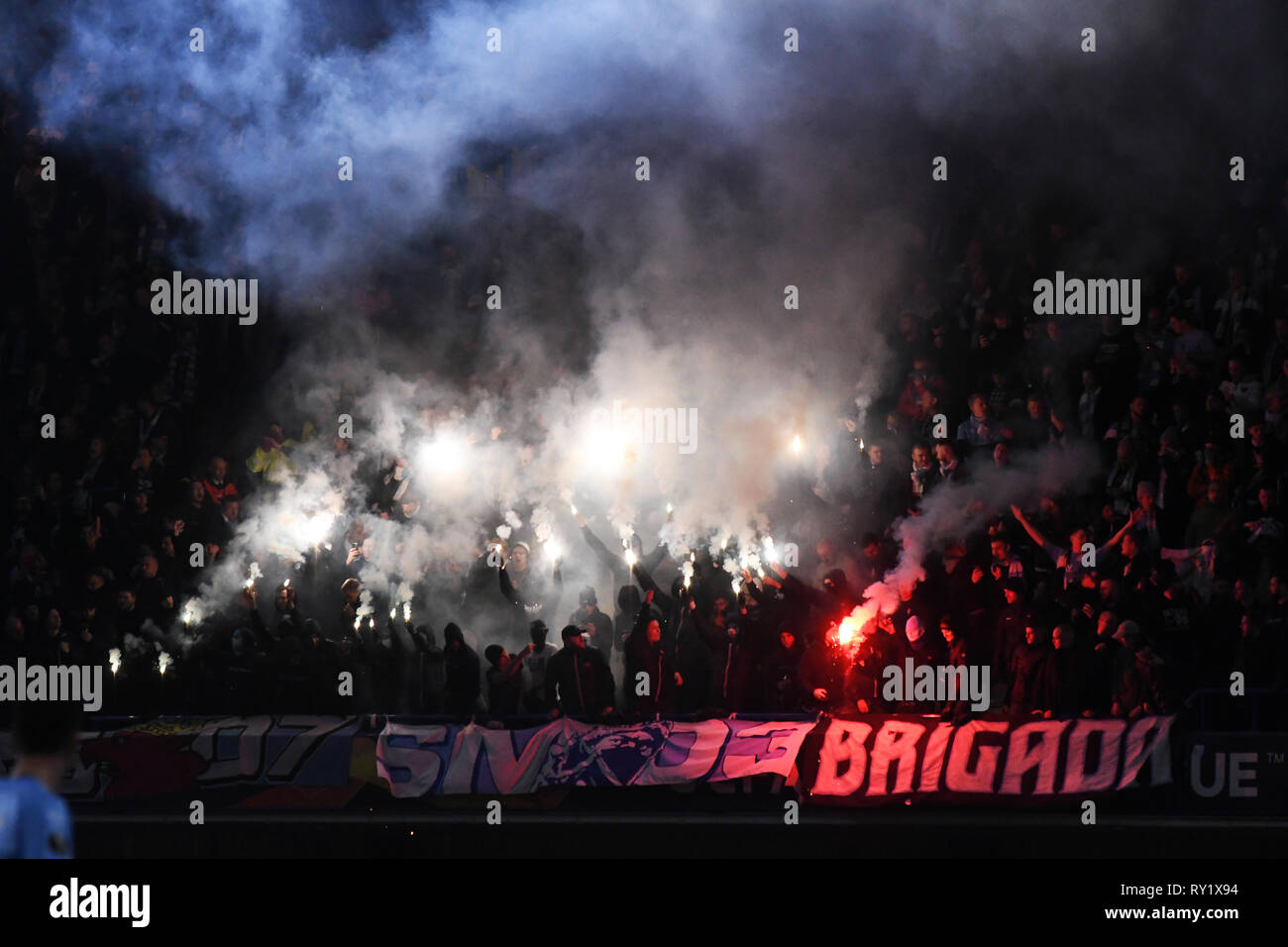 LONDON, ENGLAND - FEBRUARY 21, 2019: Malmo ultras light flares during the second leg of the 2018/19 UEFA Europa League Round of 32 game between Chelsea FC (England) and Malmo FF (Sweden) at Stamford Bridge. Stock Photo