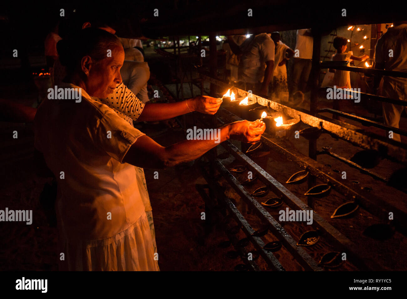 Woman lighting candle, Kataragama Temple, Sri Lanka. July 2017 Stock Photo