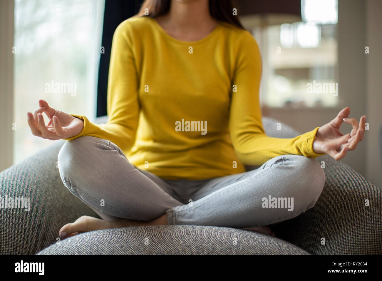 Close Up Of Peaceful Woman Meditating Sitting In Chair At Home Stock Photo
