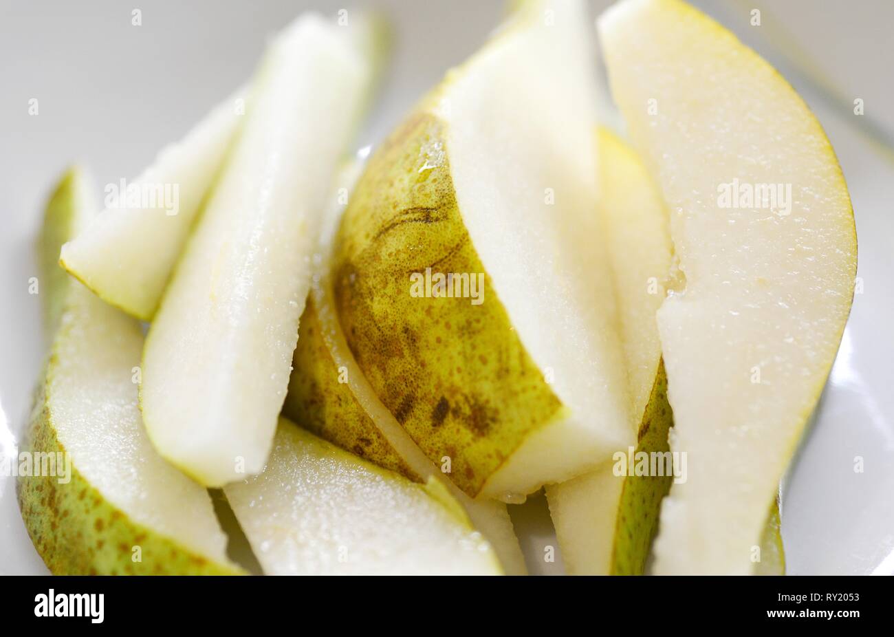 Close-up of the Fresh Pear Slices on the White Plate. Stock Photo