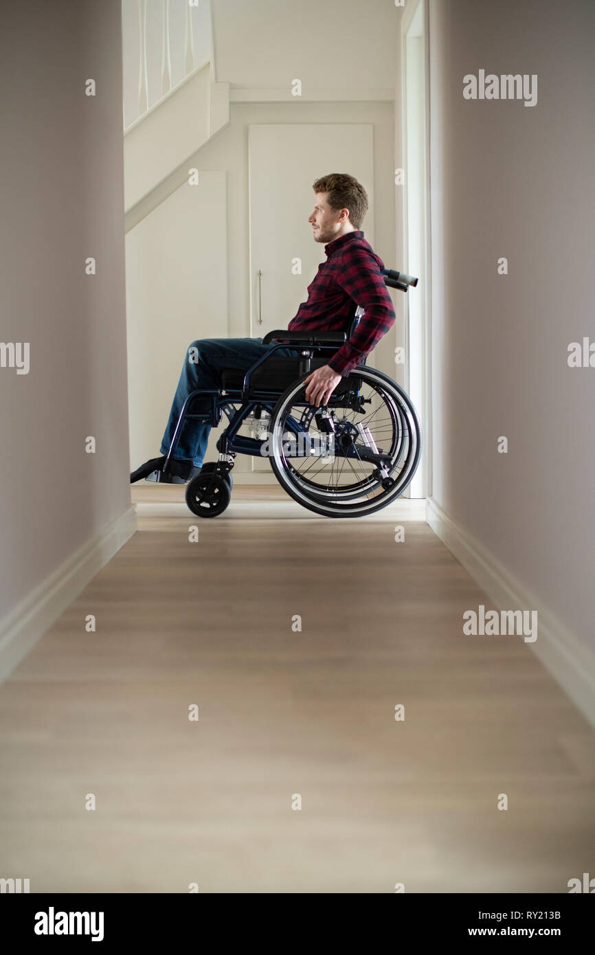 Close Up Of Man Sitting In Wheelchair At Home By Window Stock Photo