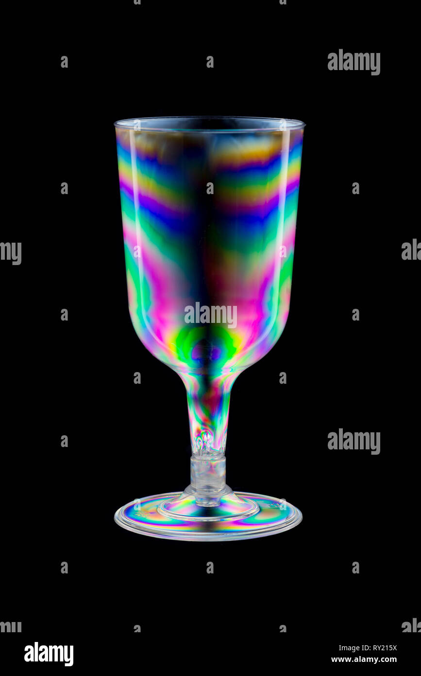 Normally invisible stress patterns made visible with polarised lighting on plastic moulded clear drinks wine glass, photo elasticity Stock Photo