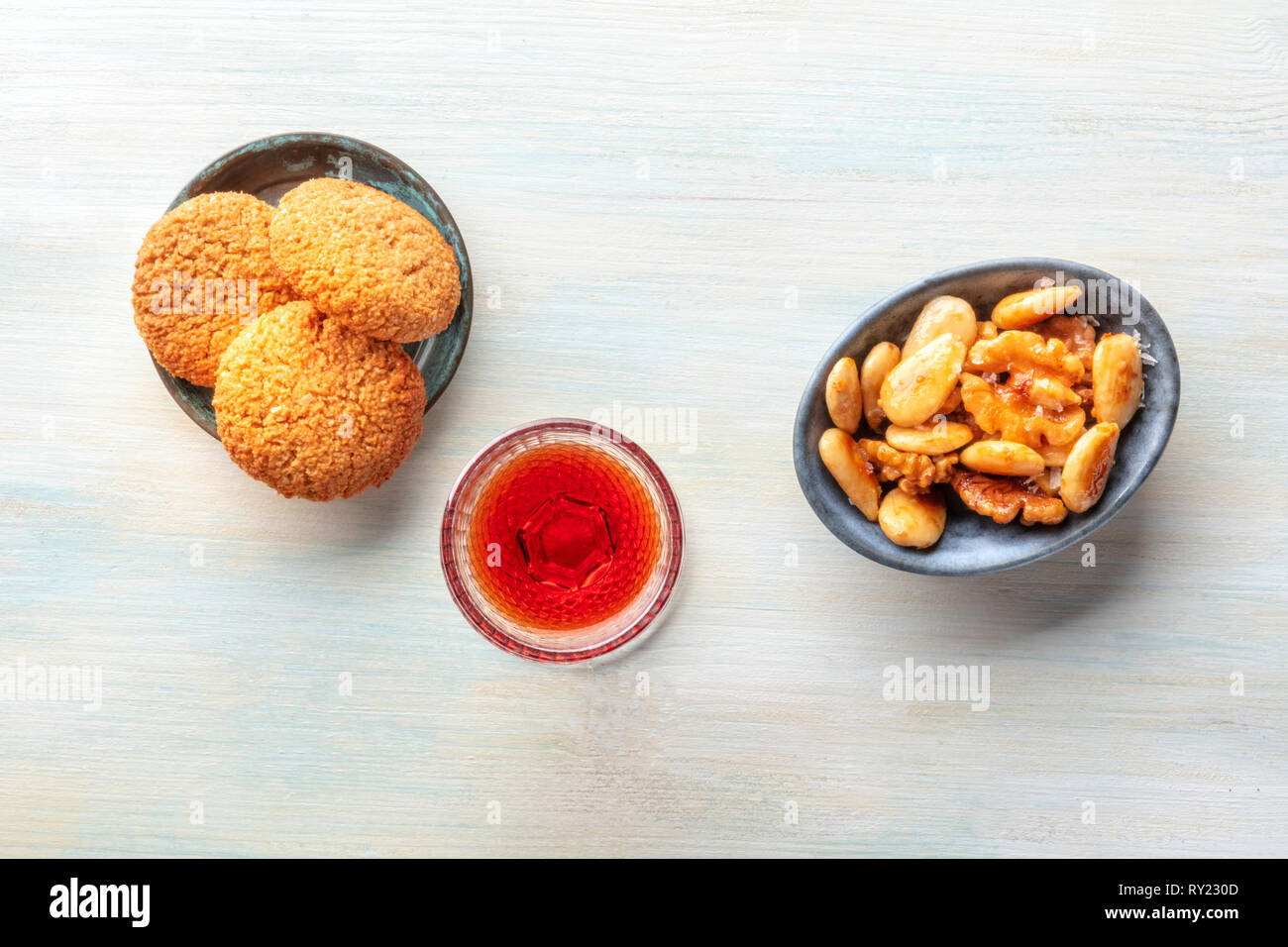 A photo of a glass of fortified wine with cookies and nuts, shot from above with copy space Stock Photo