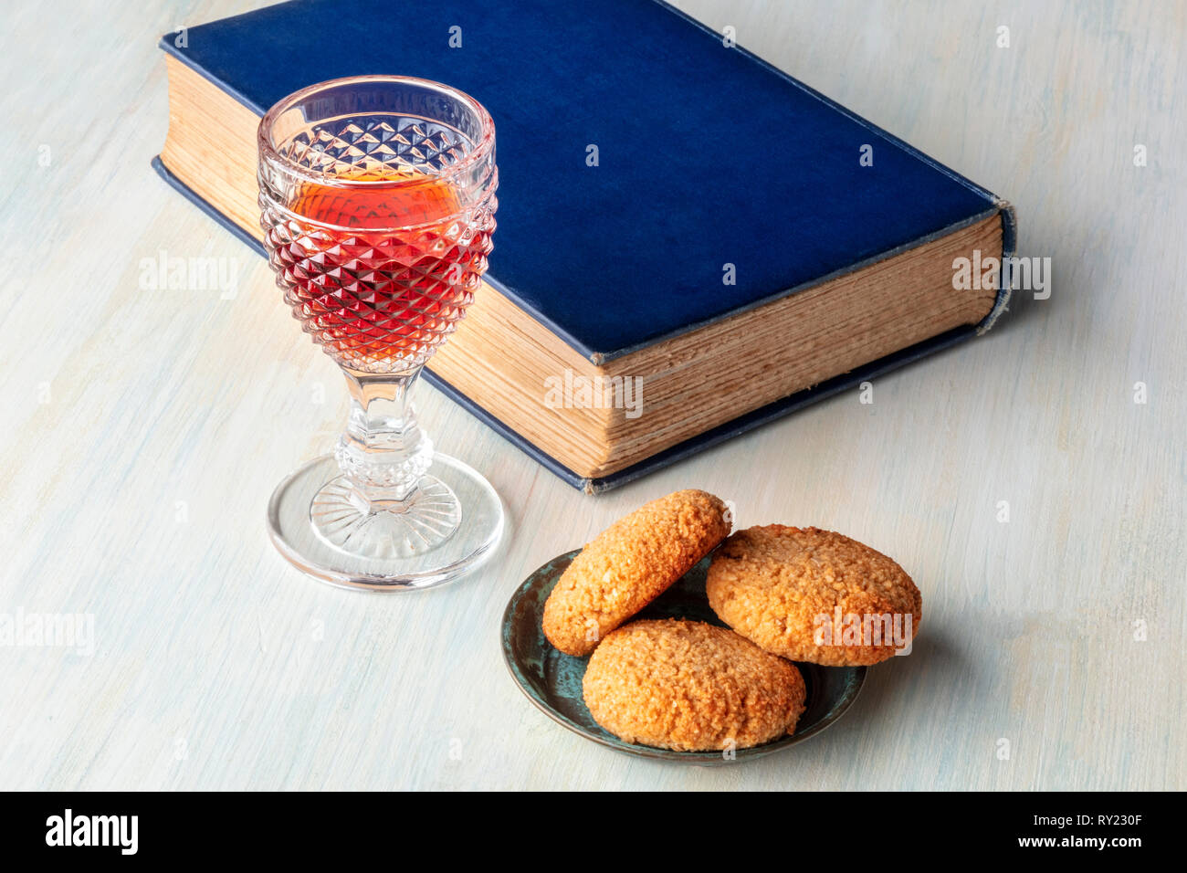 A photo of a glass of sweet wine with cookies, a book, and a place for text Stock Photo