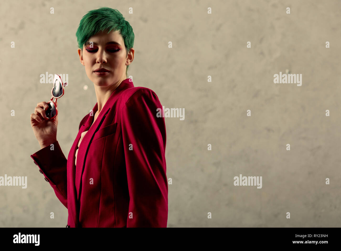 Serious nice green haired woman looking down Stock Photo