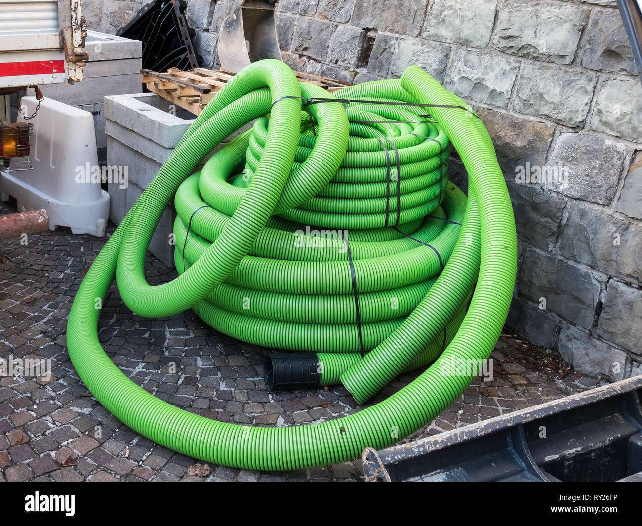 Roll of plastic pipe for road works. Protection of electric or telephone cables Stock Photo