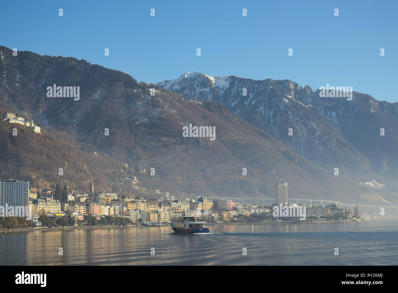 Montreux, Switzerland - 02 17, 2019: Ship cruising towards Montreux with mountains in the background. Stock Photo