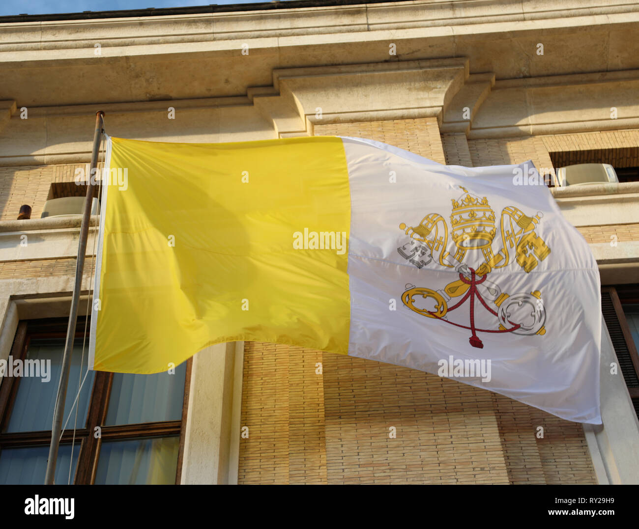 waving yellow and white flag of the Vatican papal state with the symbol of the two crossed keys Stock Photo