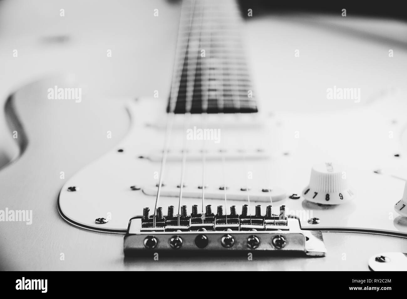 Details and connection of guitar bridge and strings. Close up black and