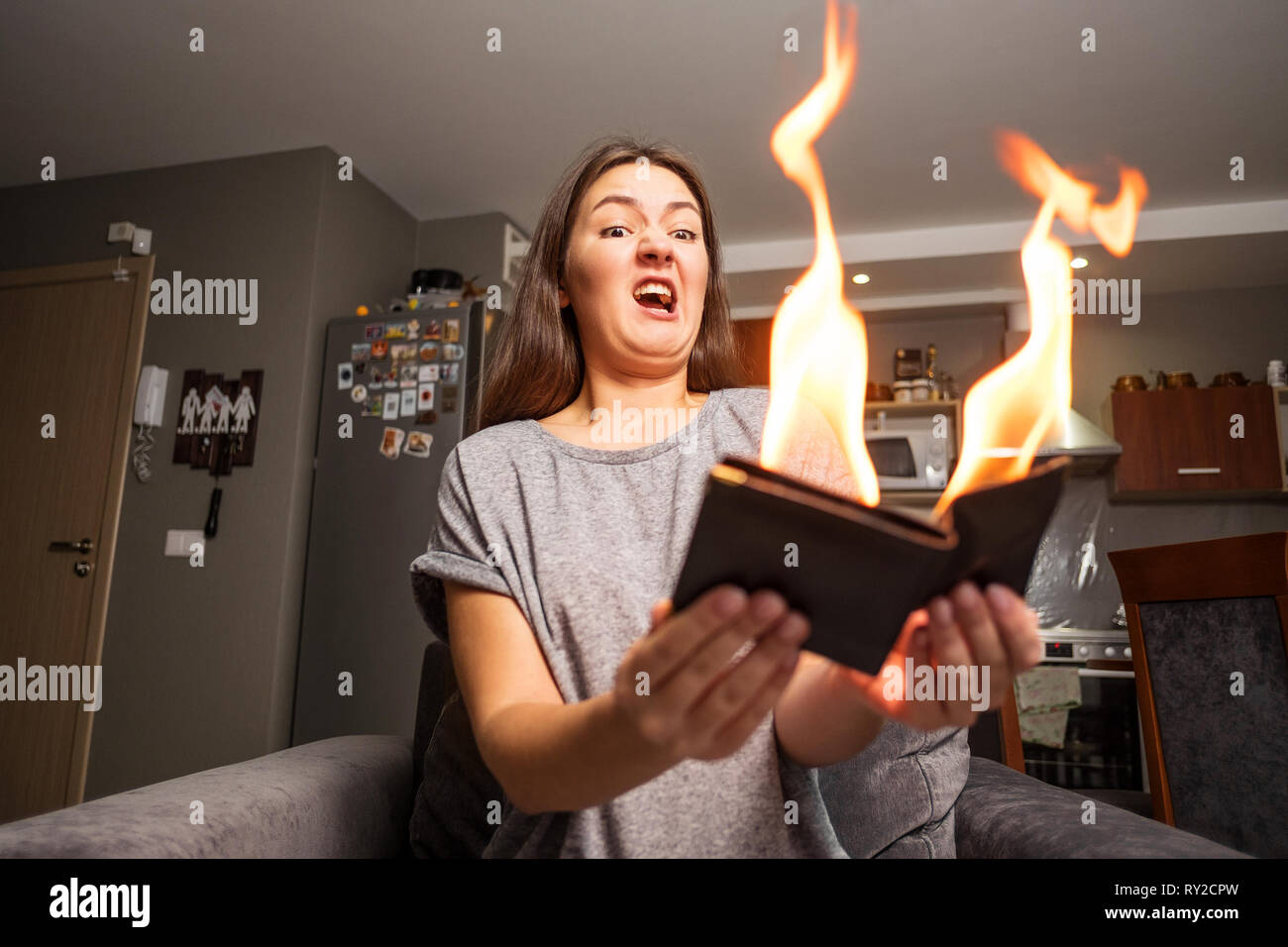 young woman holding a wallet, wallet on fire, surprised girl, magic