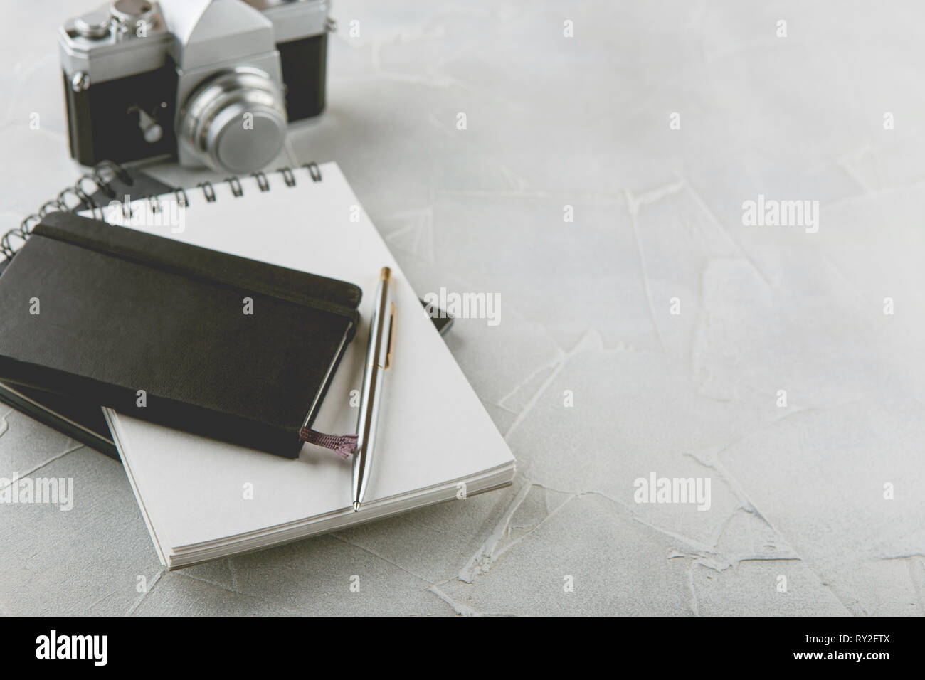 Retro photo film camera with note books, pen on light background Stock ...