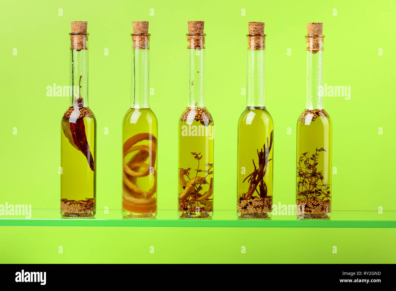 Small bottles of olive oil with herbs and spices Stock Photo - Alamy