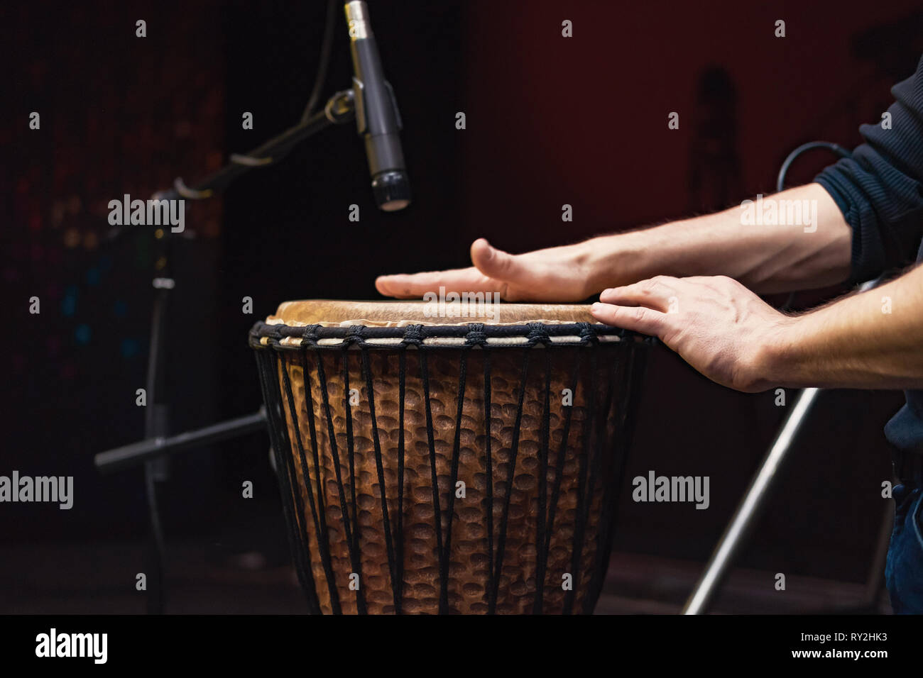 African drum, microphone studio recording, drummer beats the drum with