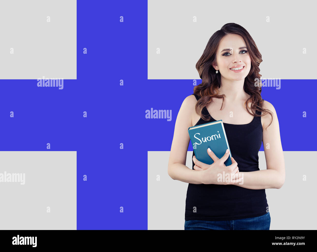 Portrait of young happy cheerful woman with book on the Finnish flag. Beautiful girl learning finnish language Stock Photo
