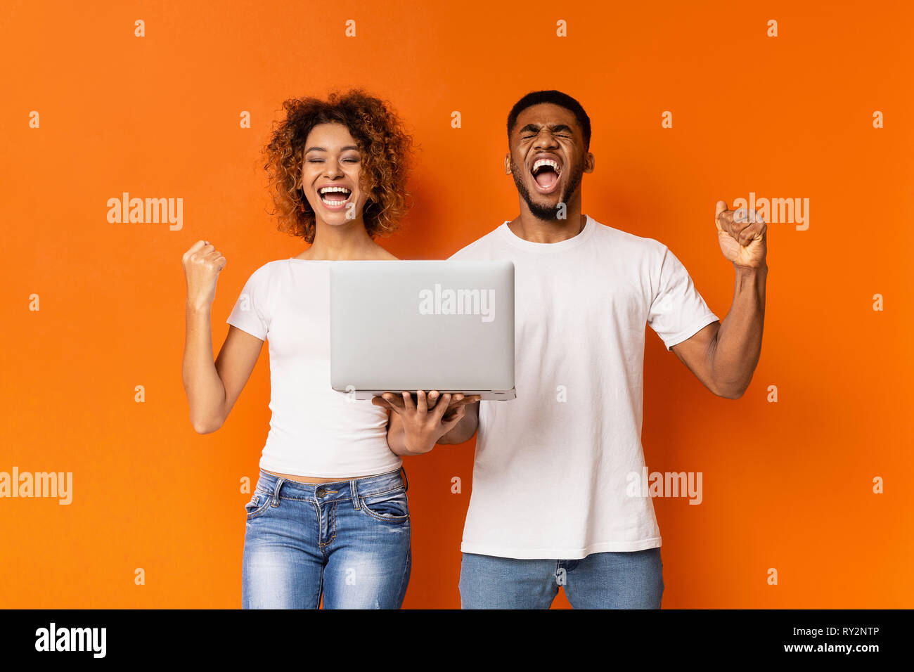 Excited black couple celebrating win with laptop Stock Photo - Alamy