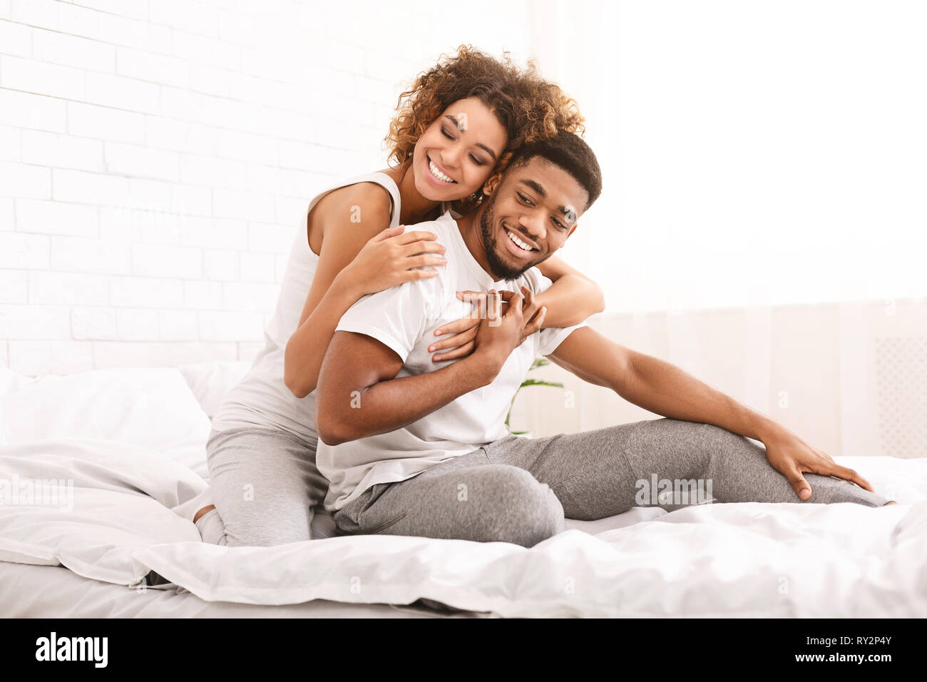 Happy couple flirting in morning on comfortable bed Stock Photo