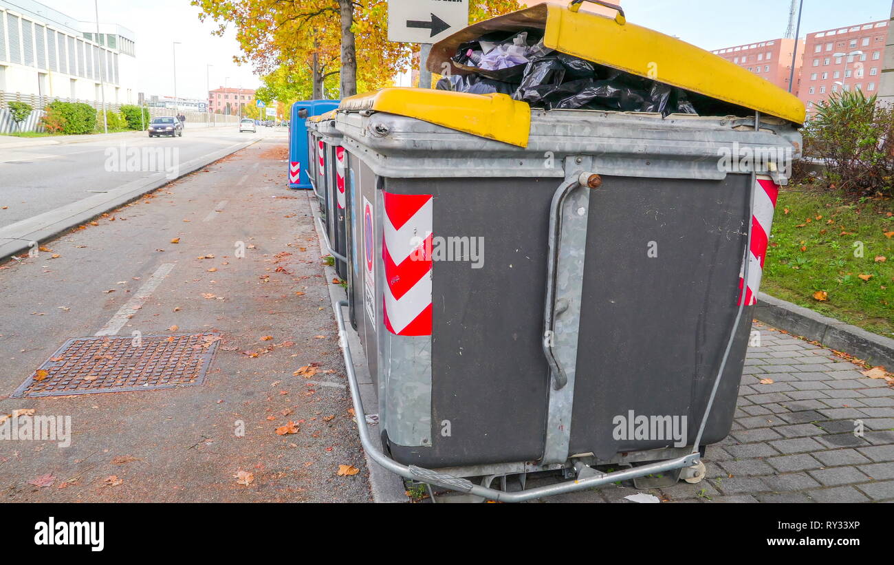 A big trashcan on the streetside  where it is already full of garbage inside in Italy Stock Photo