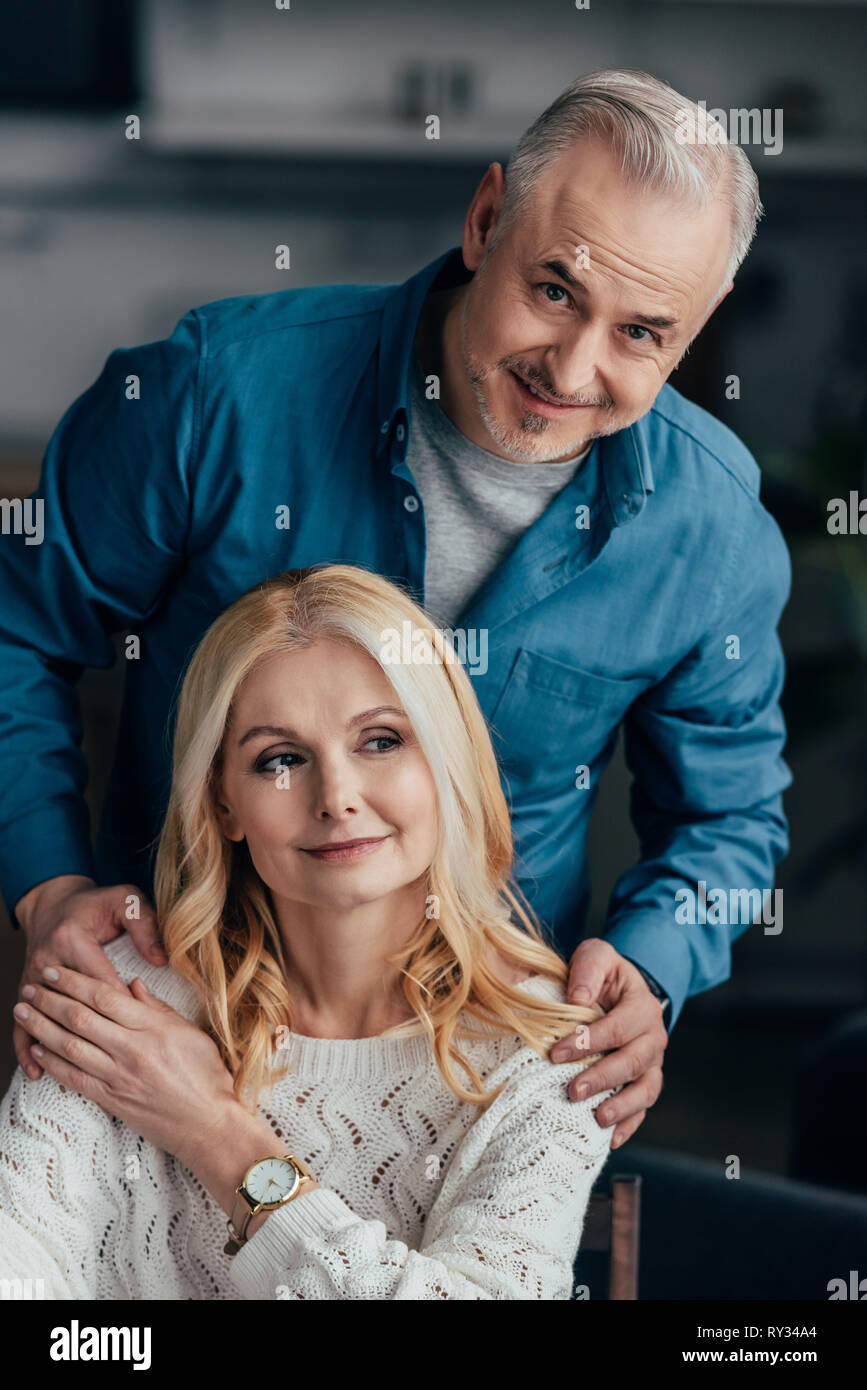handsome man embracing cheerful wife at home Stock Photo