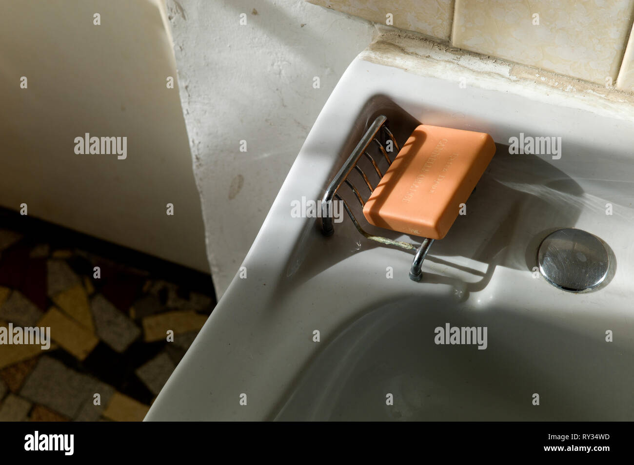 New bar of soap in old bathroom in sunlight Stock Photo