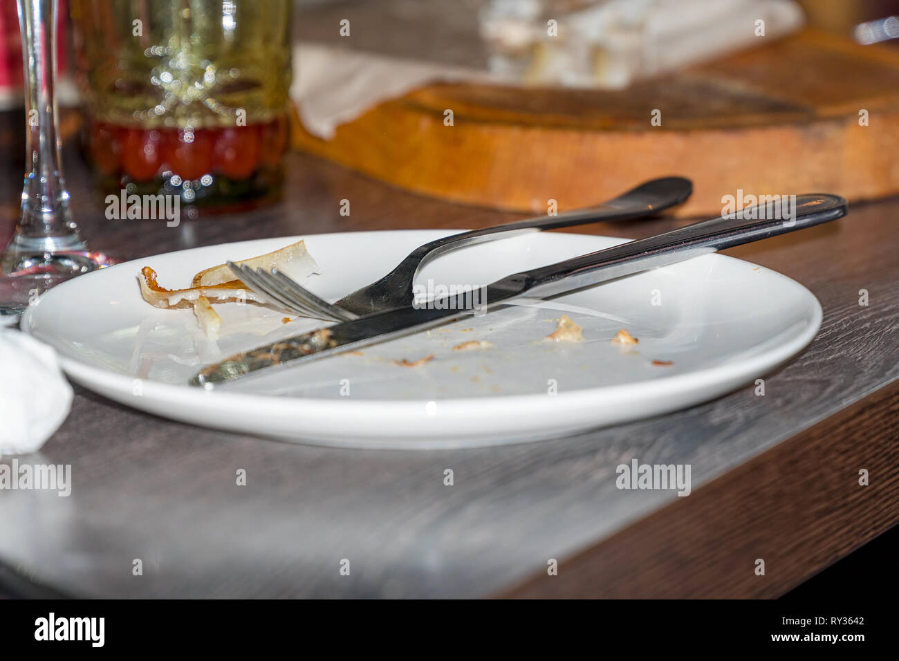 Knife and fork on dirty plate after meal Stock Photo Alamy