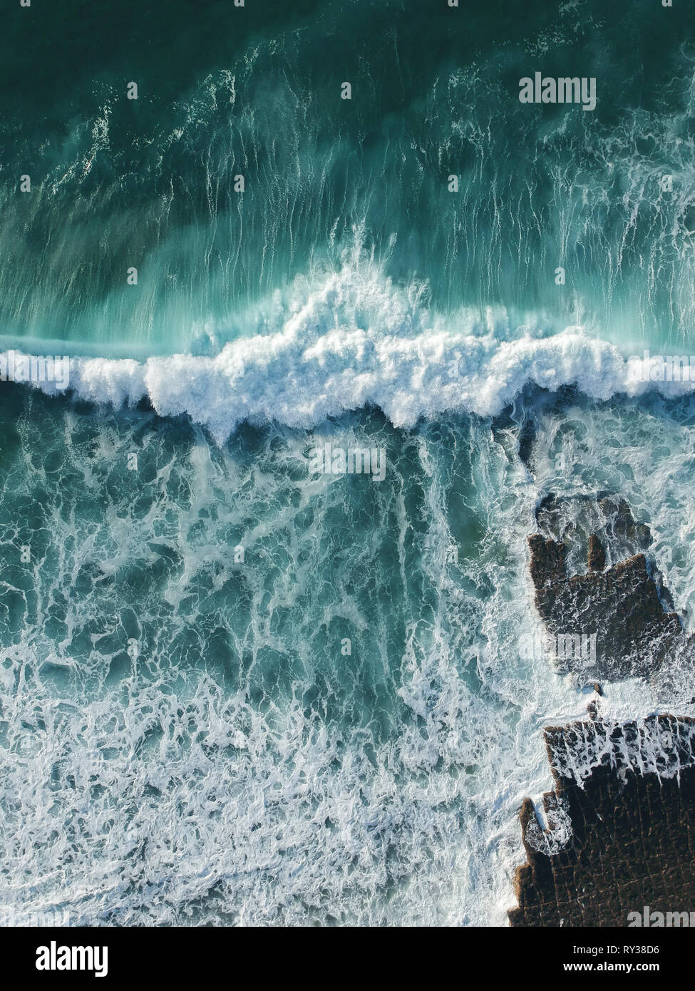 Aerial top view of ocean wave with foam. Drone Photo Stock Photo
