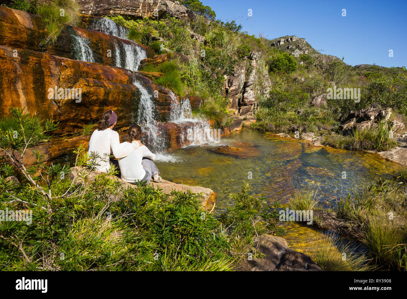 Long Haired Couple enjoying a beautiful waterfall in Brazil Stock Photo