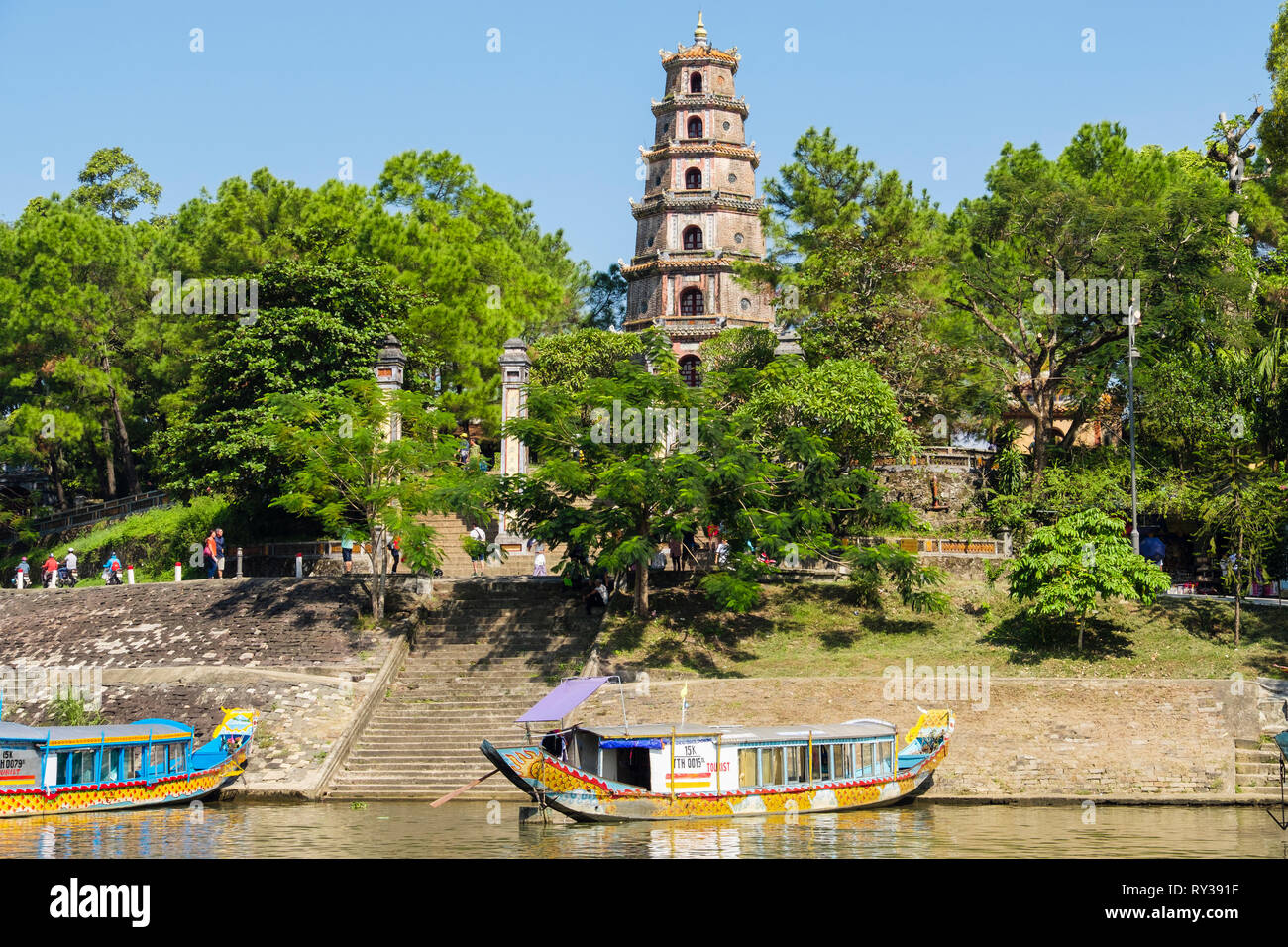 Tourist boats moored below steps outside Thien Mu Pagoda beside Song Huong Perfume River. Hue, Thừa Thien–Hue Province, Vietnam, Asia Stock Photo
