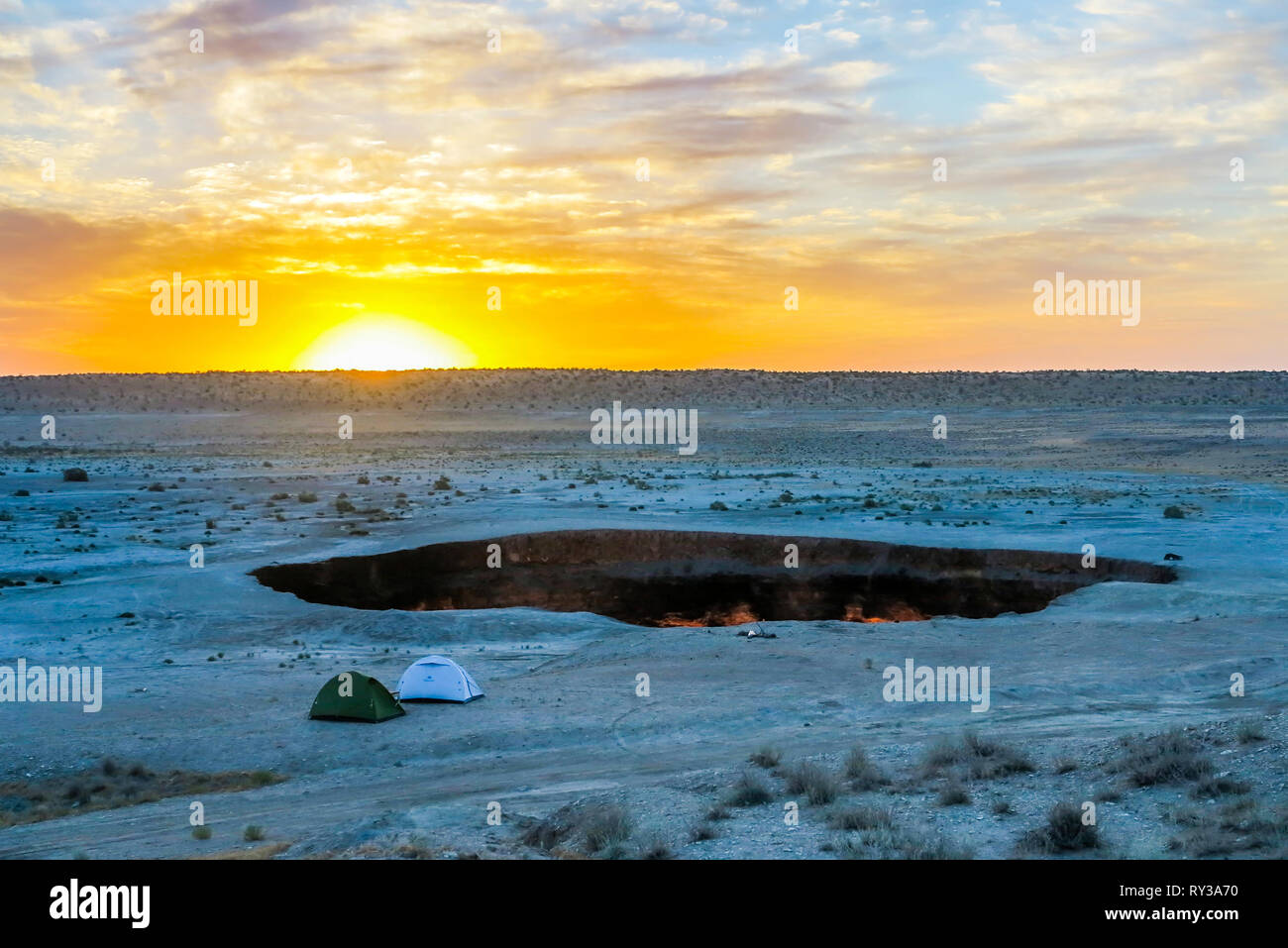 Darvaza Gas Crater Pit Breathtaking Two Tents at Sunrise Stock Photo