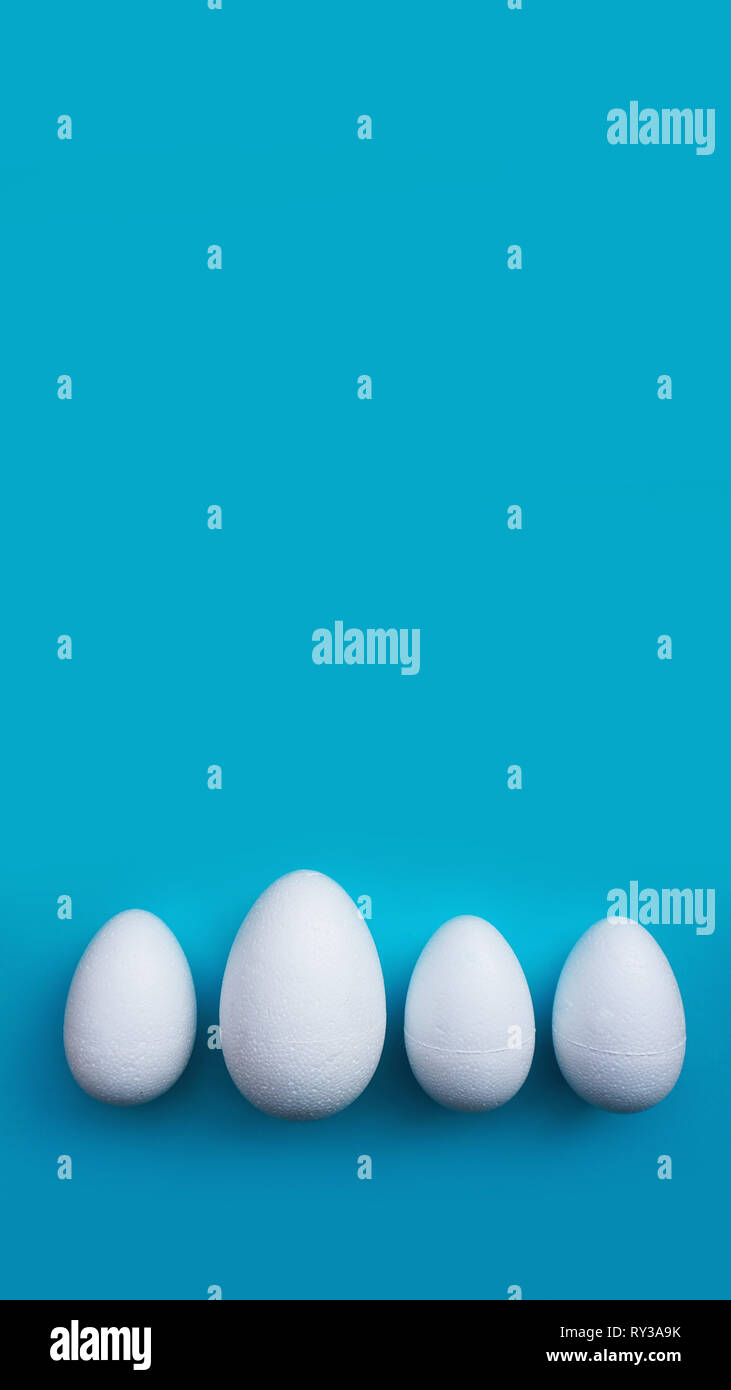White foam eggs on blue background. Flat lay, top view. Easter concept. Stock Photo