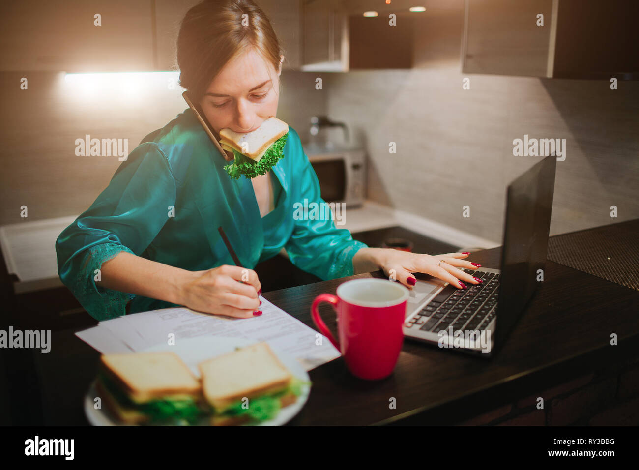 Busy woman eating, drinking coffee, talking on the phone, working on a