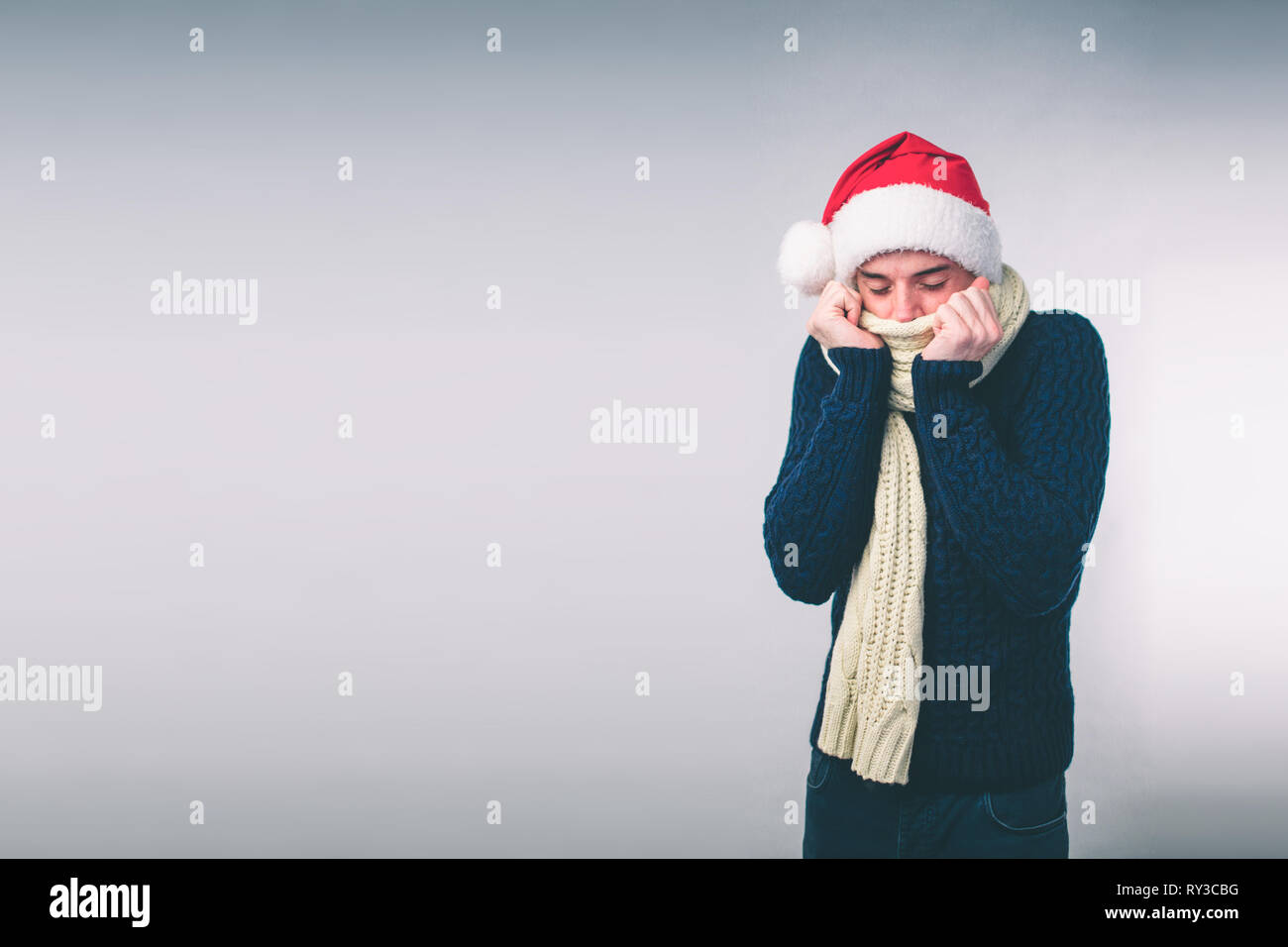 Young man in sweater feel cold over a white background Stock Photo