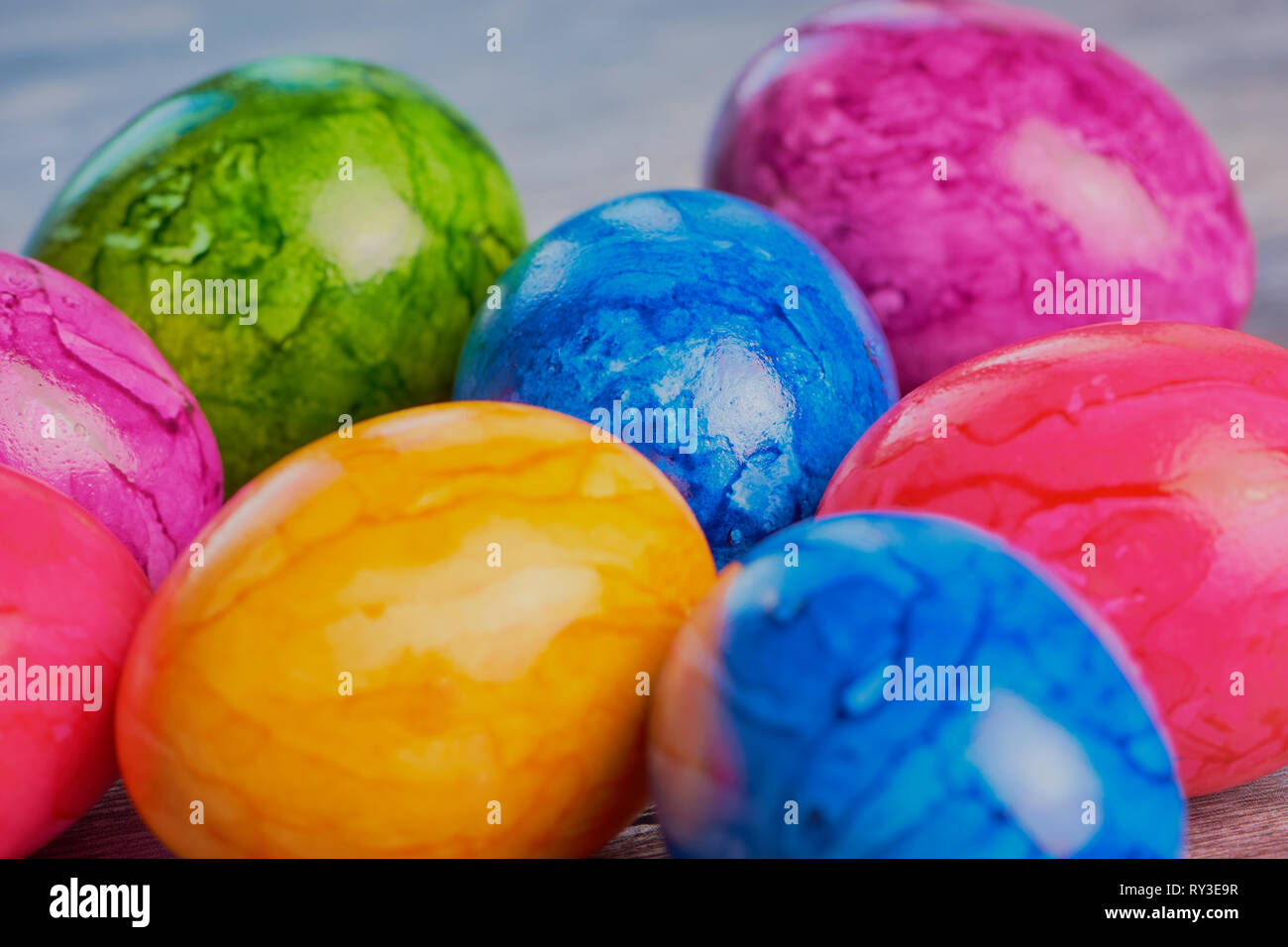 colored easter eggs close up on brown wooden surface Stock Photo