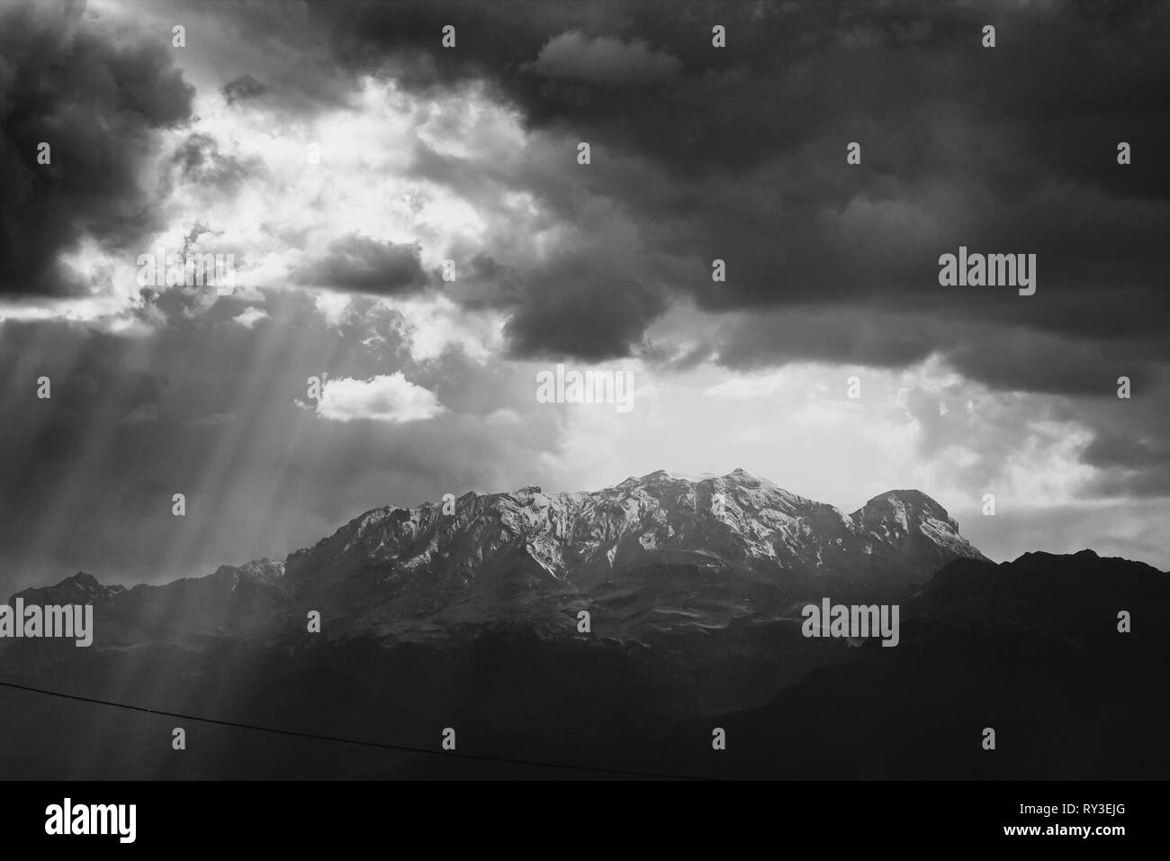 black and white photo of the iztaccihuatl summit covered by snow, ray of lights trough clouds Stock Photo