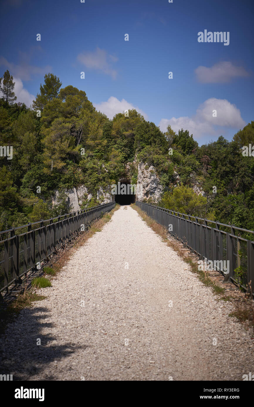 Hiking trail following the old railway (ex-ferrovia) connecting Spoleto and Norcia, in Umbria (Italy). Portrait format. Stock Photo