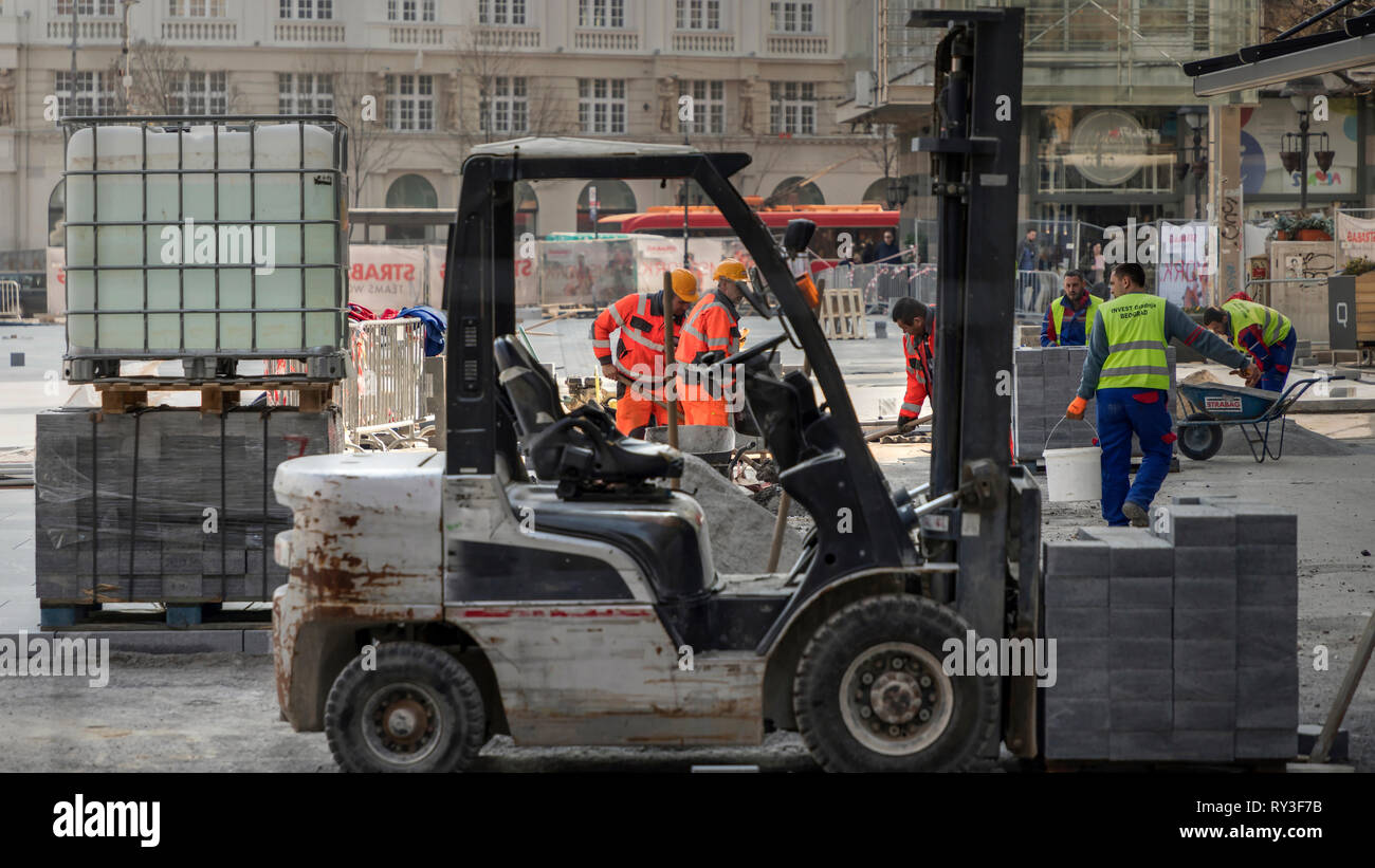 Belgrade, Serbia, Mar 1, 2019: Construction workers paving the Republic Square (Trg Republike) in pedestrian city zone Stock Photo