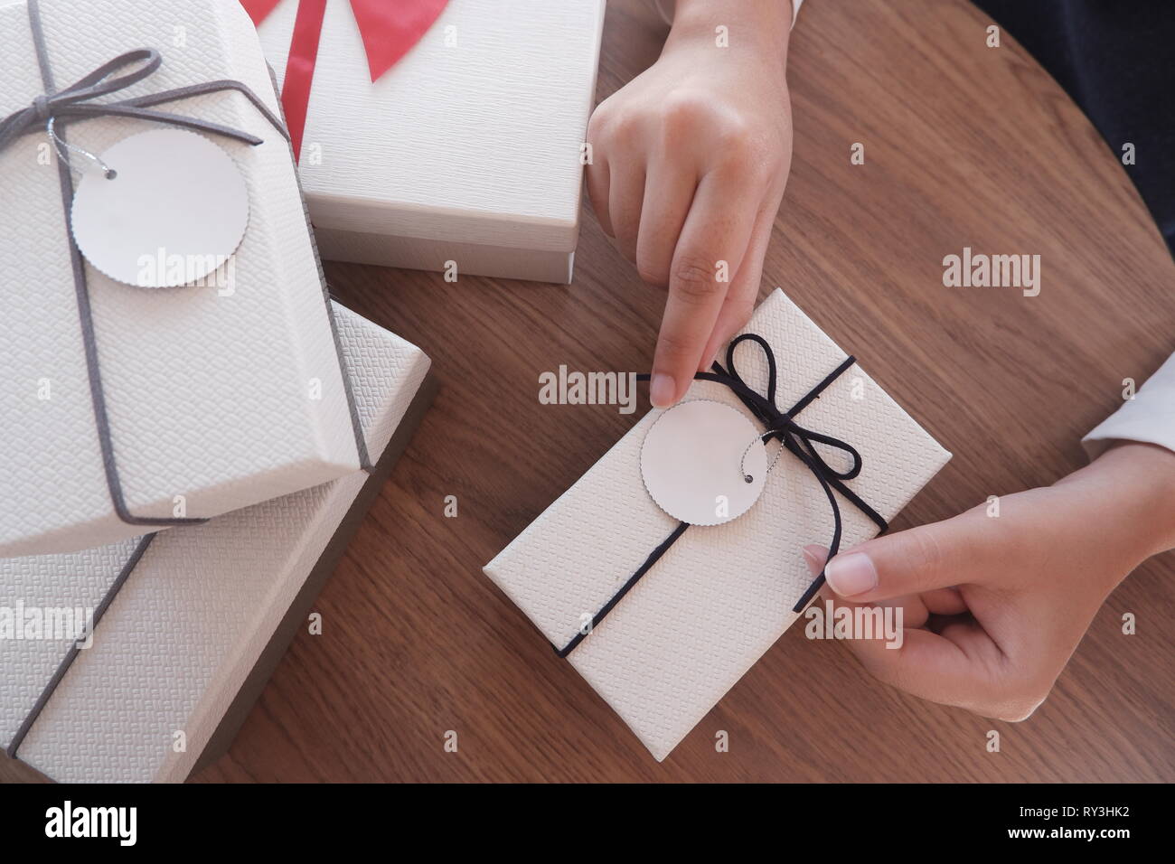 Woman hands wrapping gift box, unwrap or open present Stock Photo