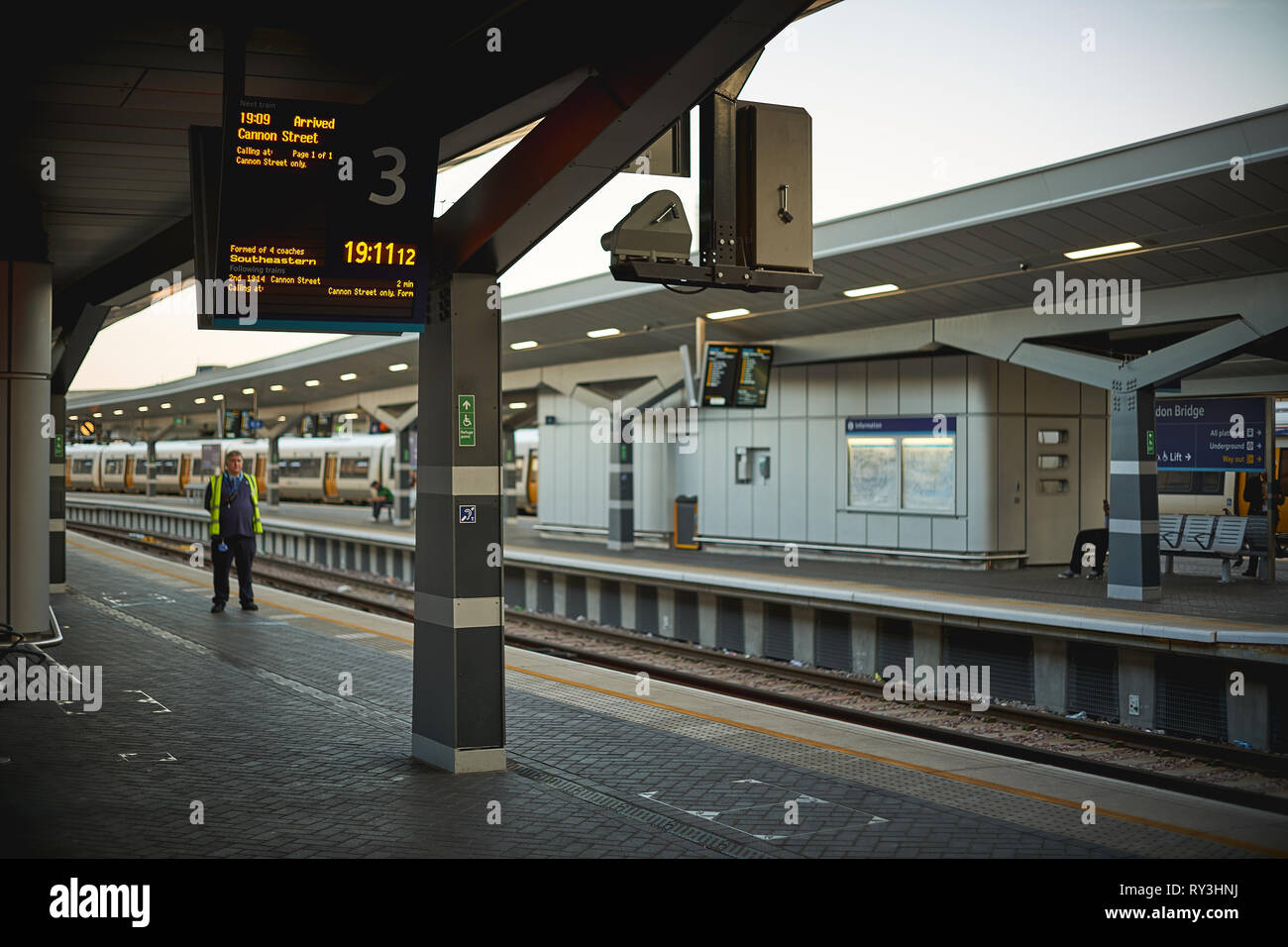 London Bridge Railing London, UK - September, 2018. A train inspector on an empty platform in ...