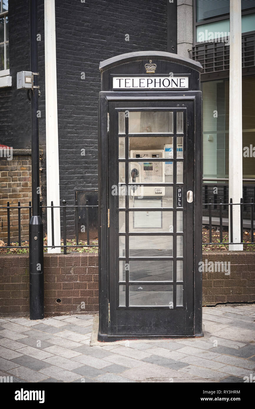 London, UK - October, 2018. An iconic black phone booth in the City of London. Stock Photo
