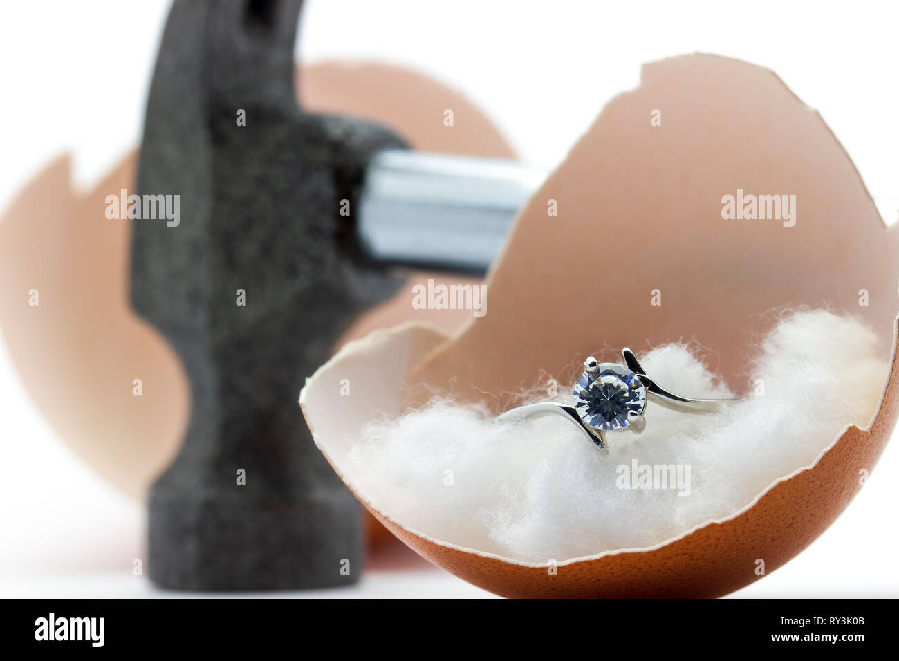 The egg shell is broken by a hammer and fake diamond ring in the egg