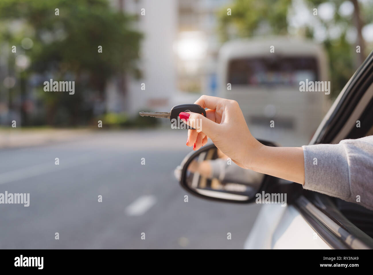 Woman holding the ignition keys of a car in her hand dangling them