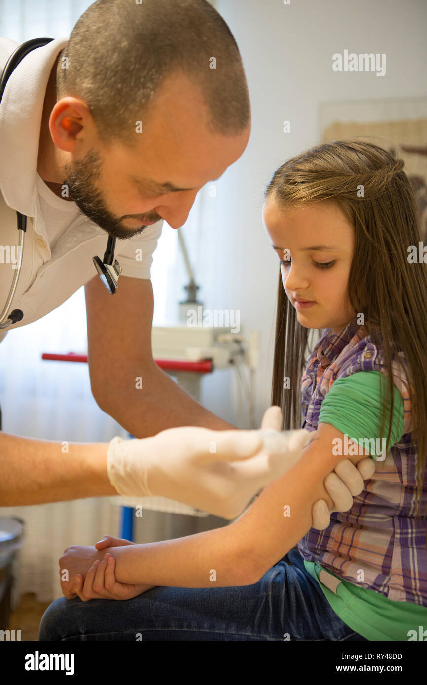 Child being given an injection at a Doctor's practice Stock Photo